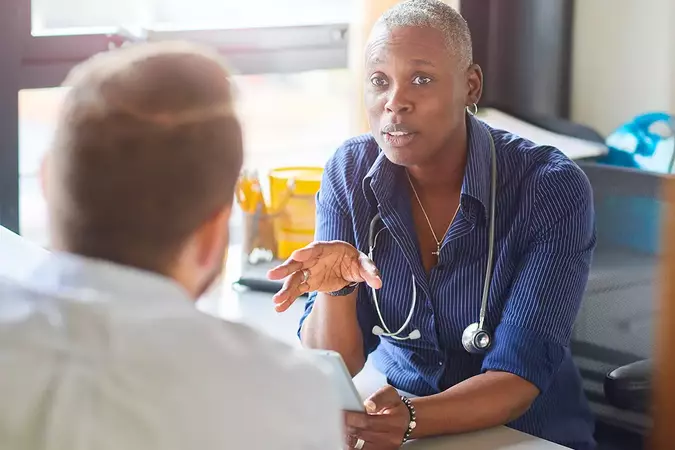 lady GP sitting at desk talking to patient, appointment booked via hosted telephony system