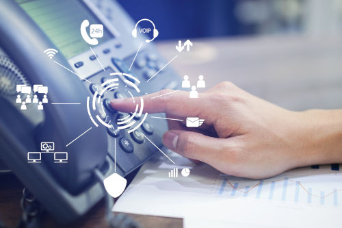 
                      A desktop hardphone in use, with symbols representing the advanced functionality of cloud-based telephony
                    