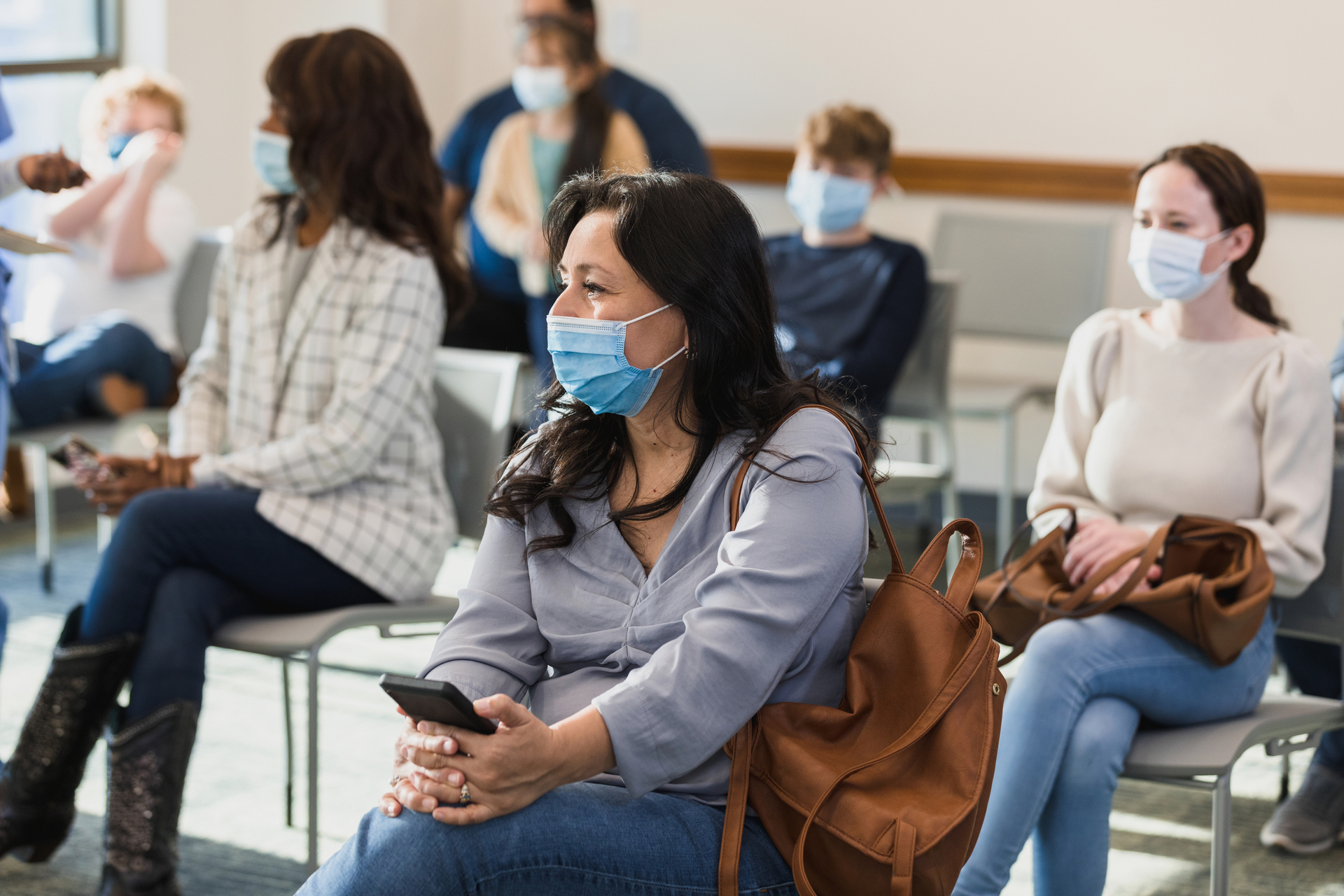 
                several people wearing face masks seated in widely spaced rows
              