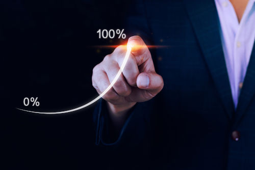 
                      A person in a suit gesturing at a chart rising to 100%
                    